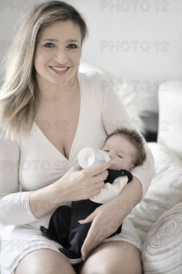 Mother feeds baby with baby bottle