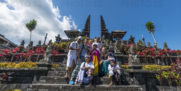 Devout Balinese posing with European tourists