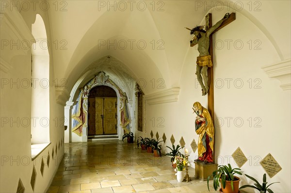 Cloister with Christ on the cross and stuccoed entrance to St. Cross Chapel