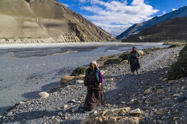 Two local women walking at river