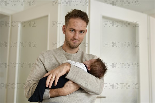 Young father holds infant