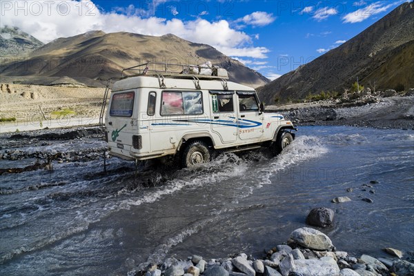 Jeep taxi is crossing a river