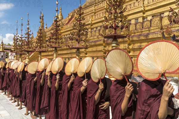 Monks with fans waiting for donations