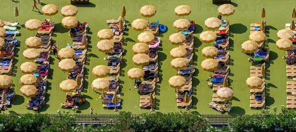 Camping guests on sun terrace with parasols
