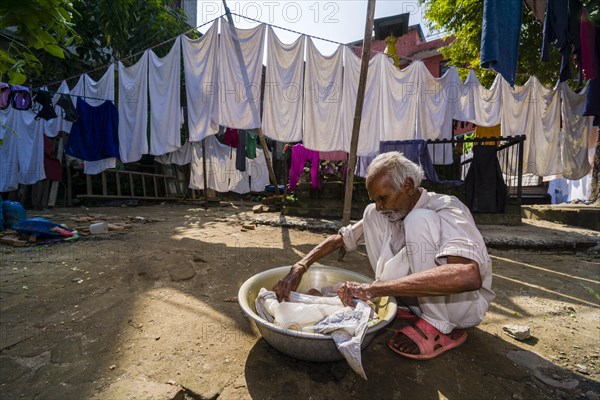 Man doing laundry by hand in courtyard