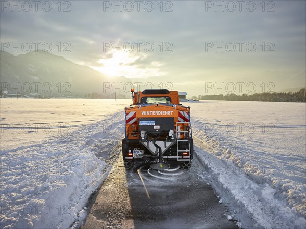 Snow plow dispenses salt on road