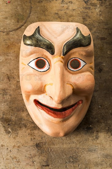 Painted wooden mask on a workbench