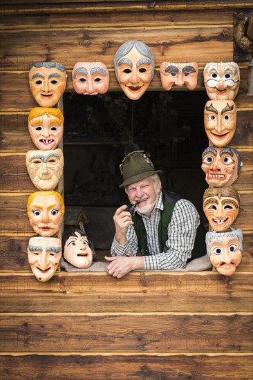 Wooden mask carver in a window