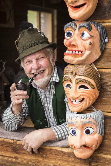 Wooden mask carver in a window