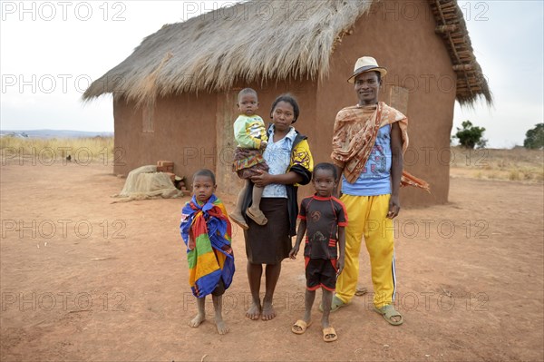 Family with three children in front of hut