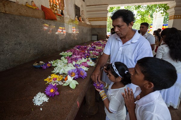 Devout Buddhists put offerings in prayer room