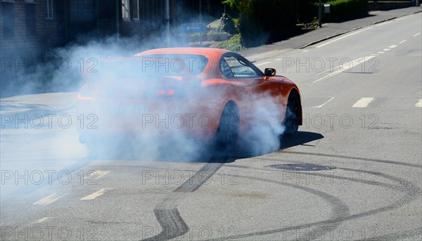 A car burning tire on a street