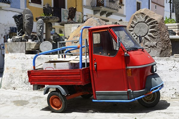 Ape-Tricycle in front of Obsidian Sculptures