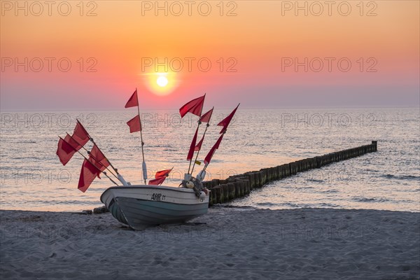 Fishing boat on the beach at sunset