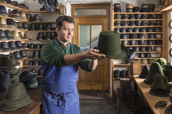 Hatter examining finished wool felt hat