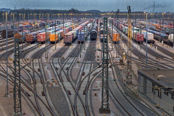 Parked freight cars on tracks at dusk