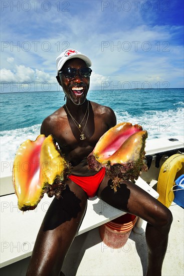 Diving instructor Brendal Stevens opening a Strombus