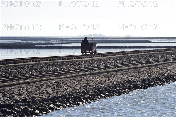 Wagon rolling over dam in Wadden Sea