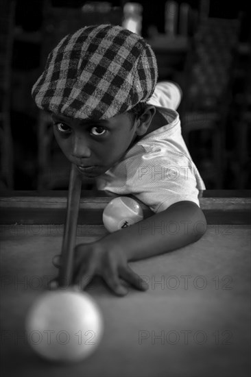 Boy playing billiards