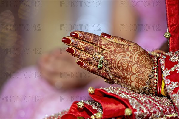 Traditional bridal jewelry and henna decoration on the hands of the bride during a religious ceremony at a Hindu wedding