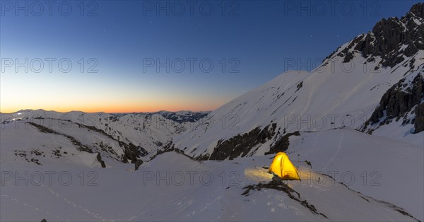 Illuminated tent in the snow on the Madelejoch