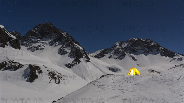 Illuminated tent in the snow on the Madelejoch