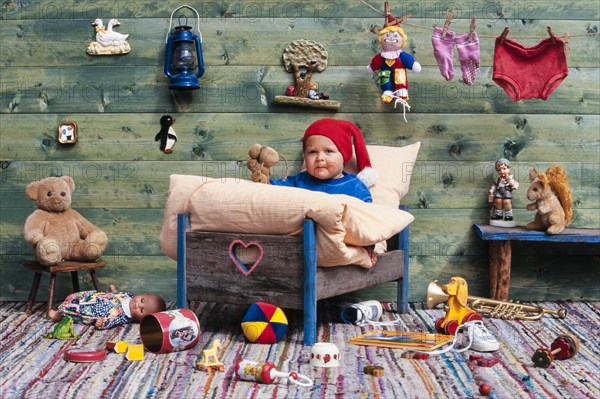 Three-year-old girl in bed with toys