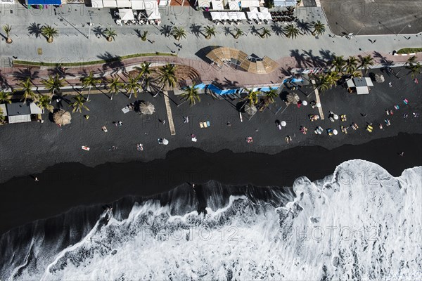 Black sandy beach with wave hem