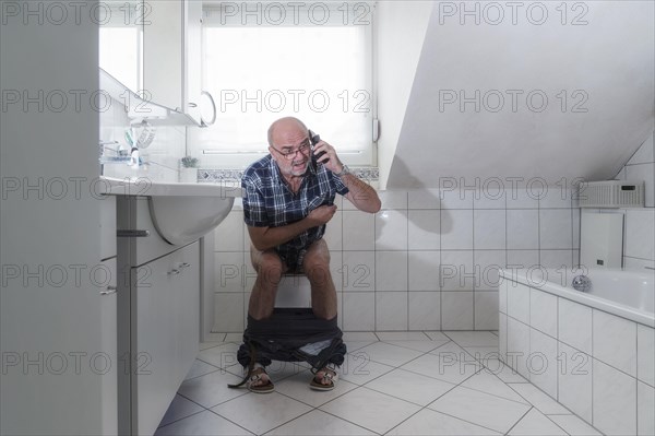 Senior man sitting on the toilet