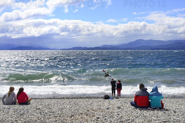 People sitting on the beach of Lago Nahuel Huapi