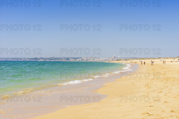 People relaxing on the beach next to Armacao de Pera