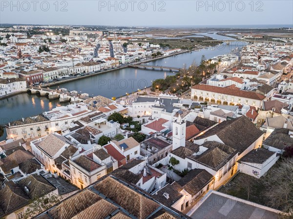 City view with roman bridge over Gilao river in old fishermen's town in the evening light