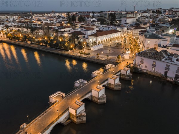 City view with roman bridge over Gilao river in old fishermen's town in the evening light
