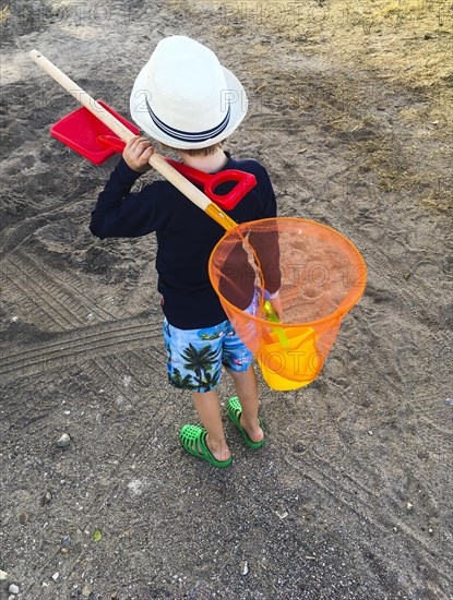 Boy with a fishing net on the beach