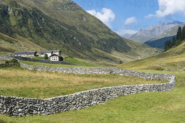 Natural stone wall on pasture in mountain valley