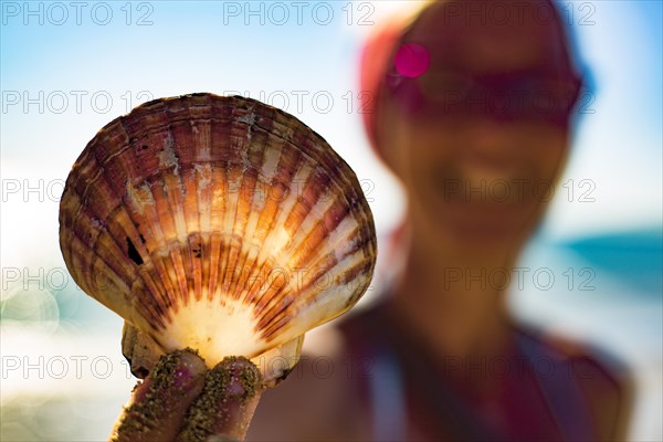 Woman holding a fan shell