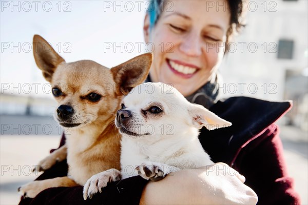 Laughing woman with two dogs on her arm