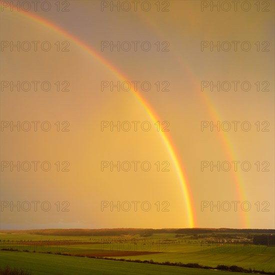 Double rainbow over agricultural landscape