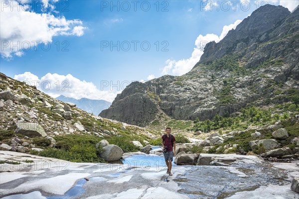 Young man hiking by the river Golo in the mountains