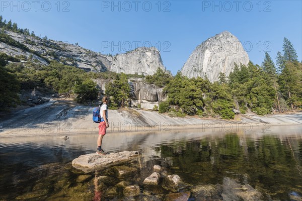 Young man standing on rock in Merced River