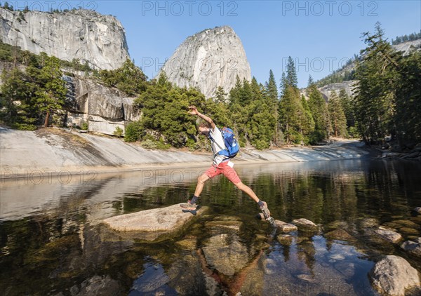 Young man jumping between stones