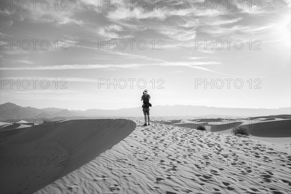 Young man photographing sand dunes
