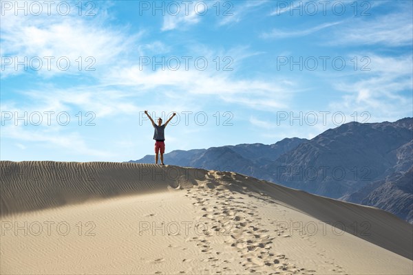 Young man standing on sand dune