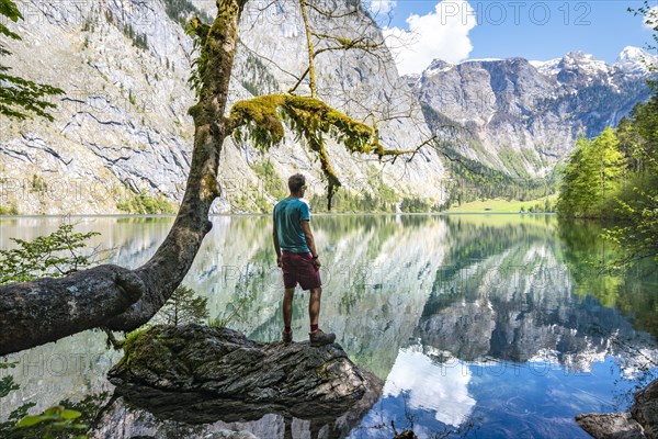 Young man standing on stone in water