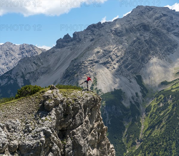 Hiker stands in front of mountain scenery