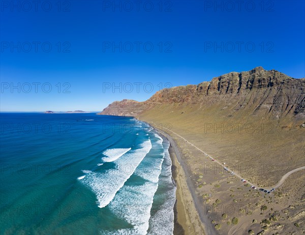 View on beach Playa Famara with mountain range Risco de Famara