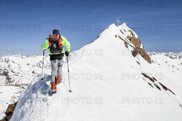 Ski tourer on ridge ascending Finailspitze in Schnals at Schnalstal Glacier