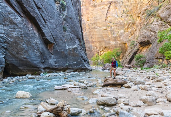 Hiker standing on a rock next to a river