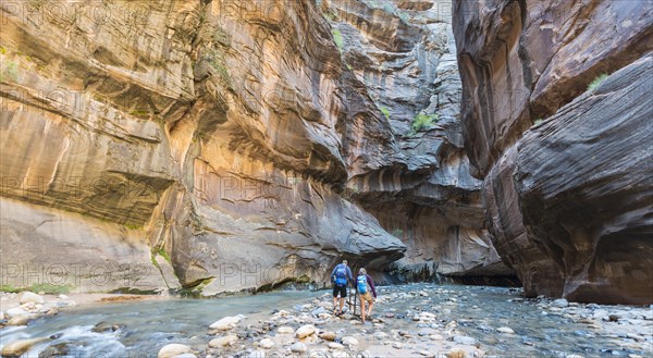 Hikers walking through river