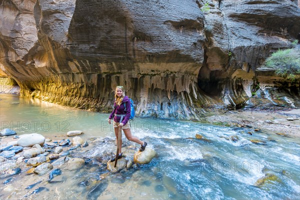 Hiker crossing river via rocks